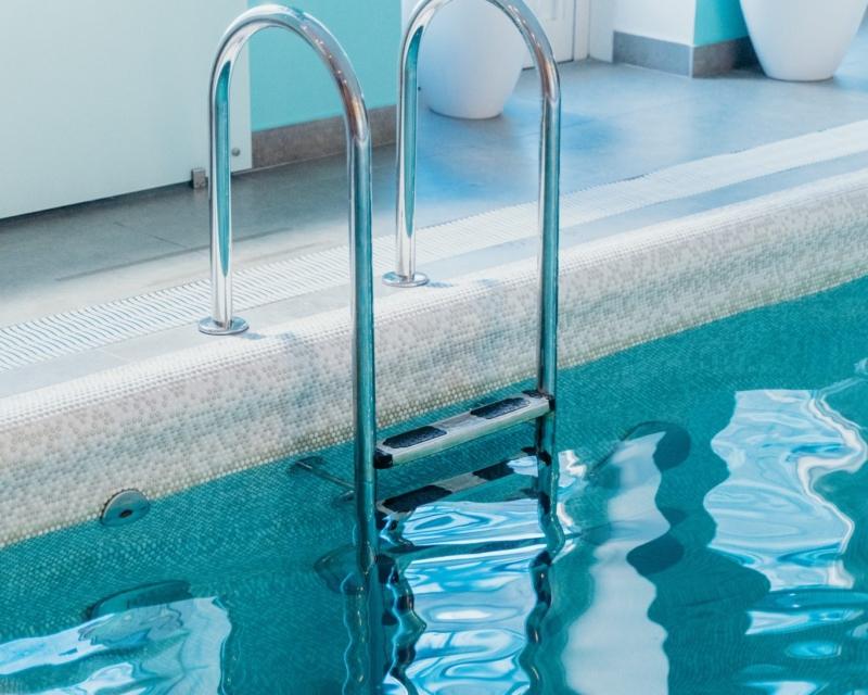 A swimming pool with silver metal ladder - 5 common swimming pool problems